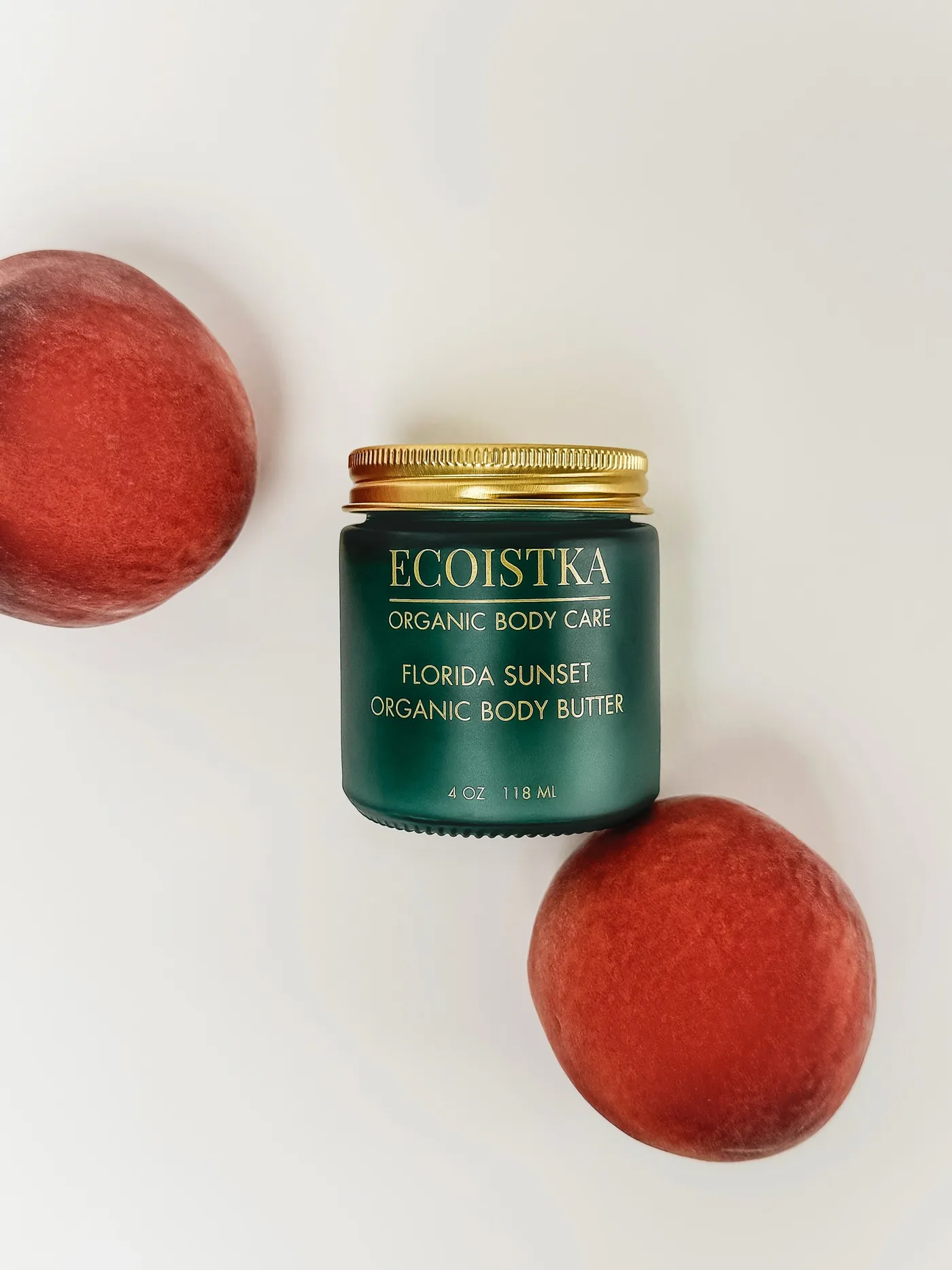 Florida Sunset body butter jar between two peaches, from the product shoot