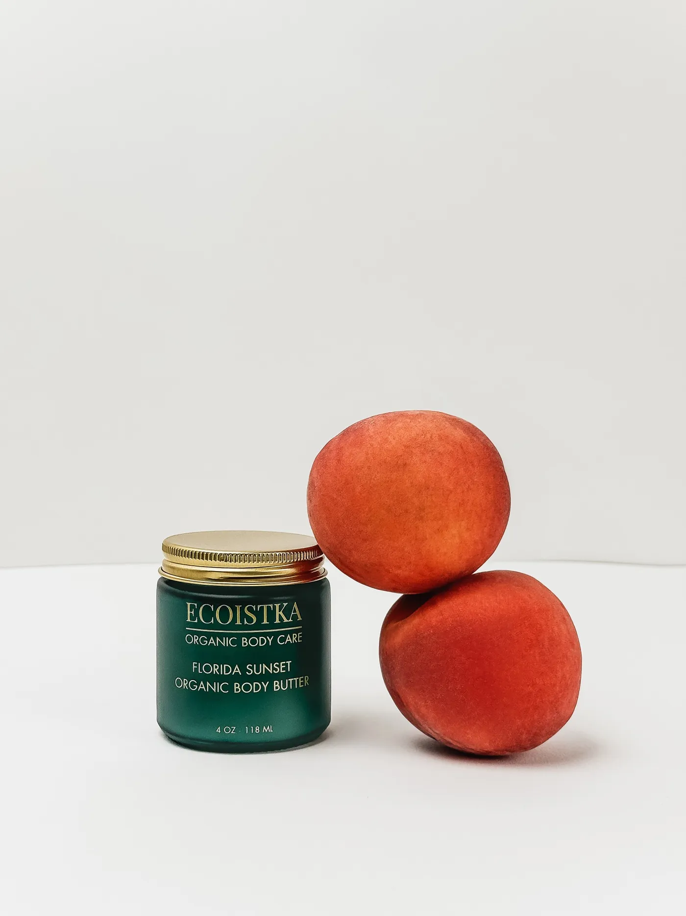 Florida Sunset jar beside stacked peaches on a white studio background