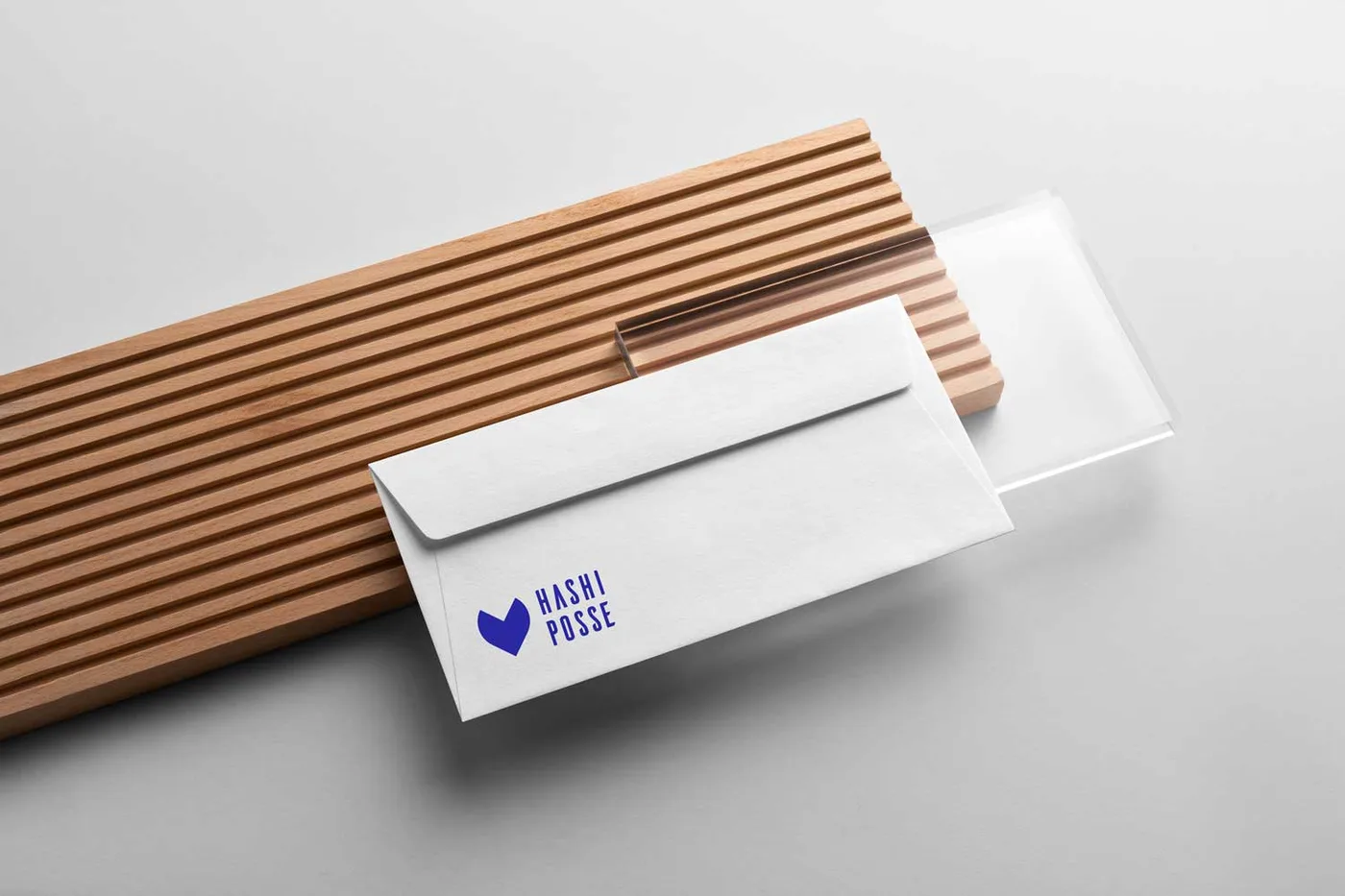 The Hashi Posse logo, a blue heart mark and condensed wordmark, on a white envelope
